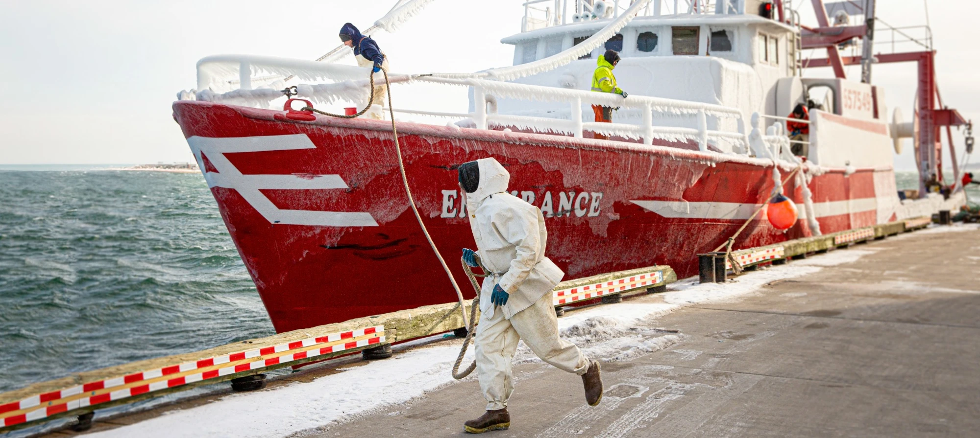 A commercial fisherman working on the dock beside a fishing boat
